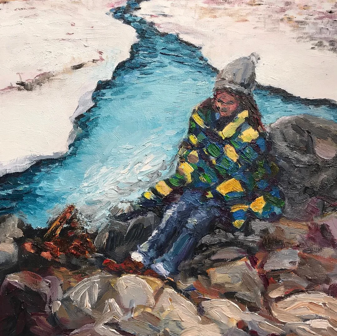 Seated traveler beside a blue glacial stream